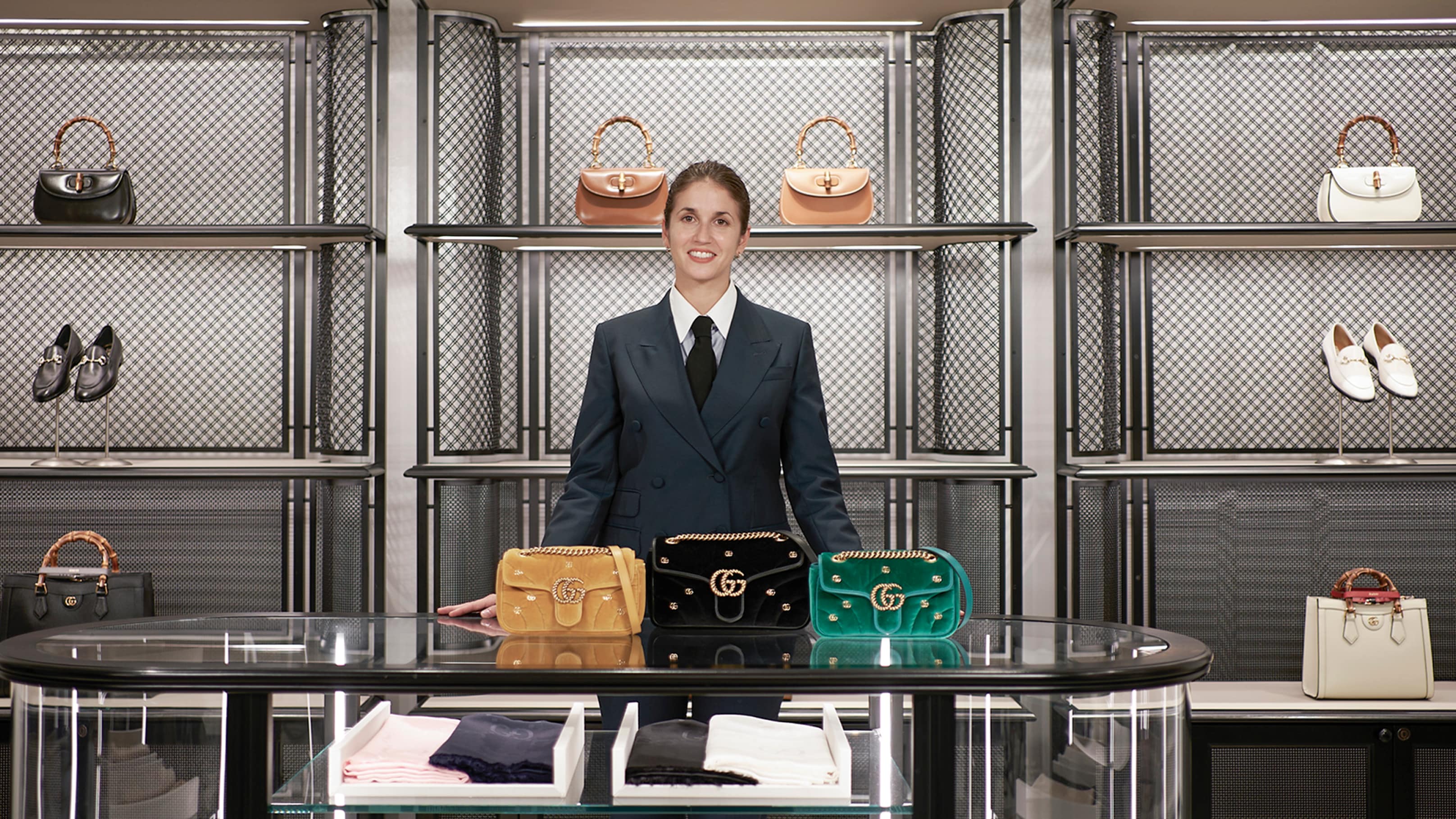 A Gucci Client Advisor is in the Digital Showroom with signature Gucci items such as the GG Marmont and Horsebit loafers.