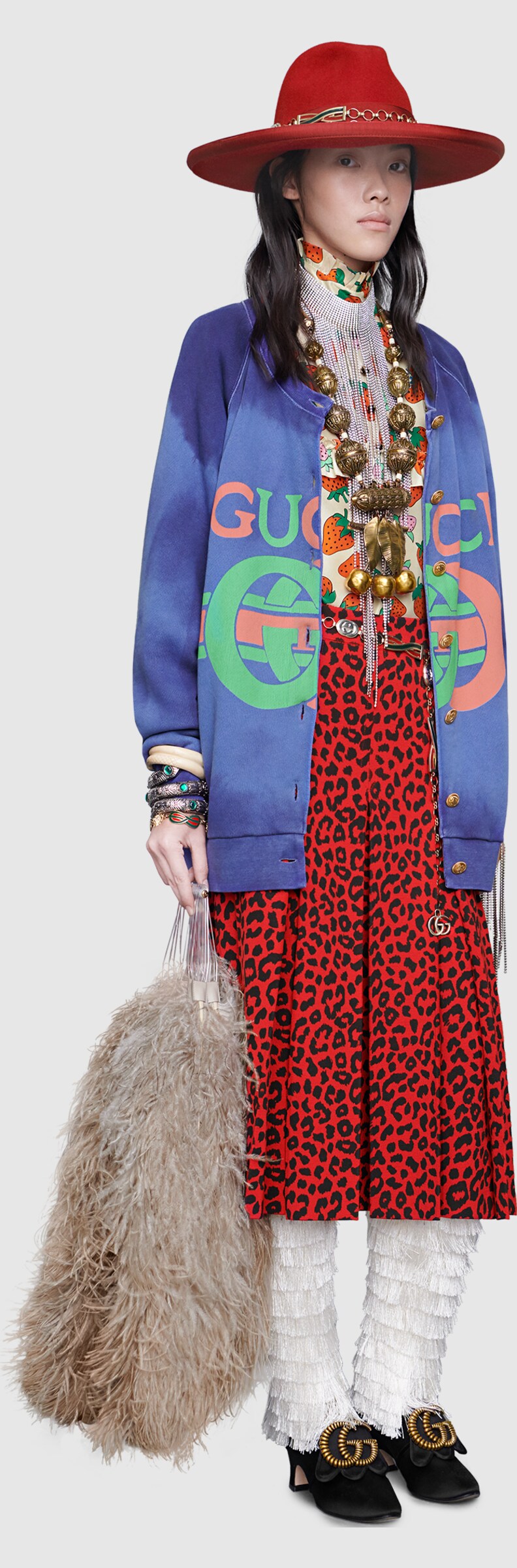 A model wearing Collier en métal avec cristaux, Jupe à imprimé léopard, Bracelet serpent gravé, Sweat-shirt en coton avec logo Gucci, Bracelet serpent triple avec cristaux, Haut en soie à imprimé Gucci Strawberry