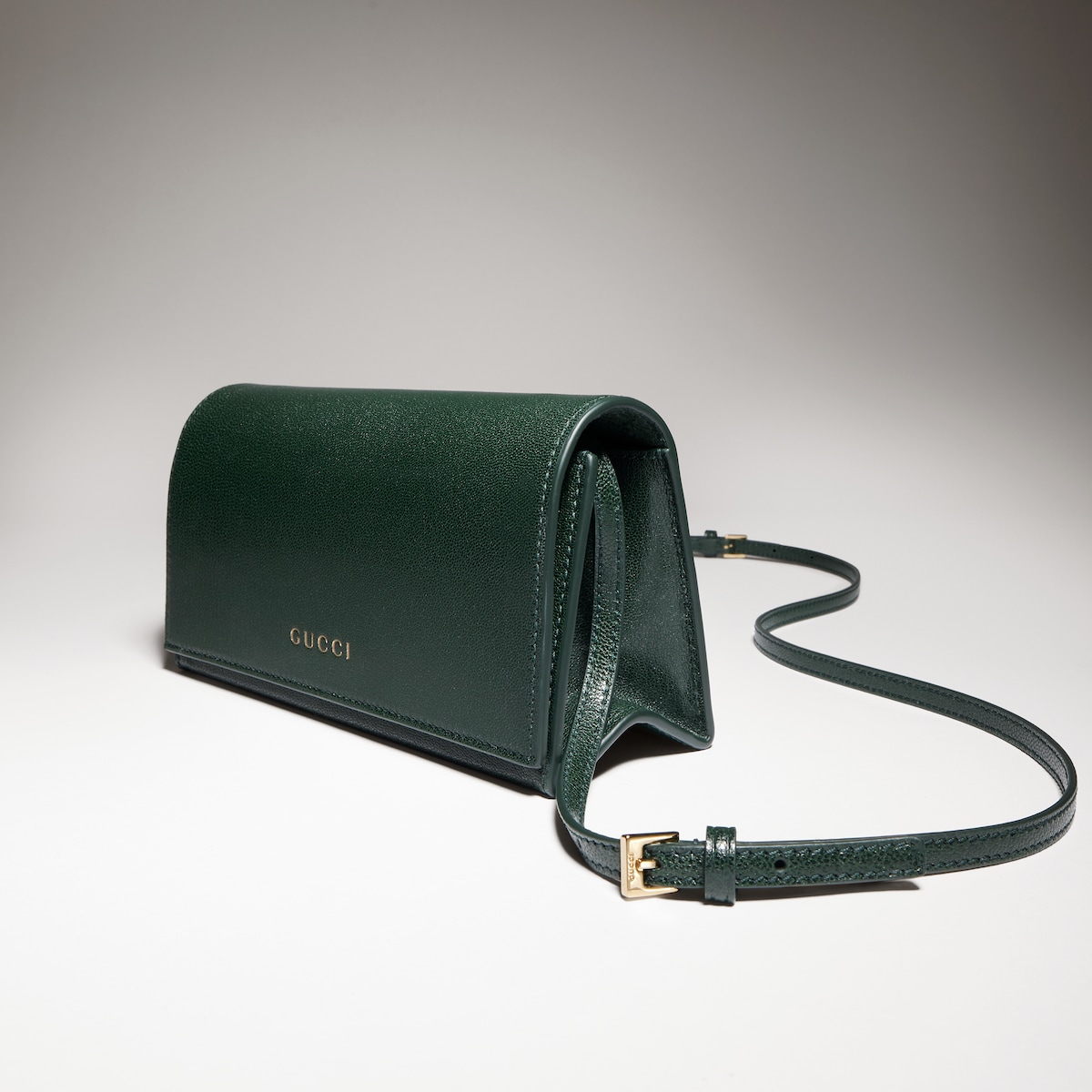 Mini pouch with strap in green leather