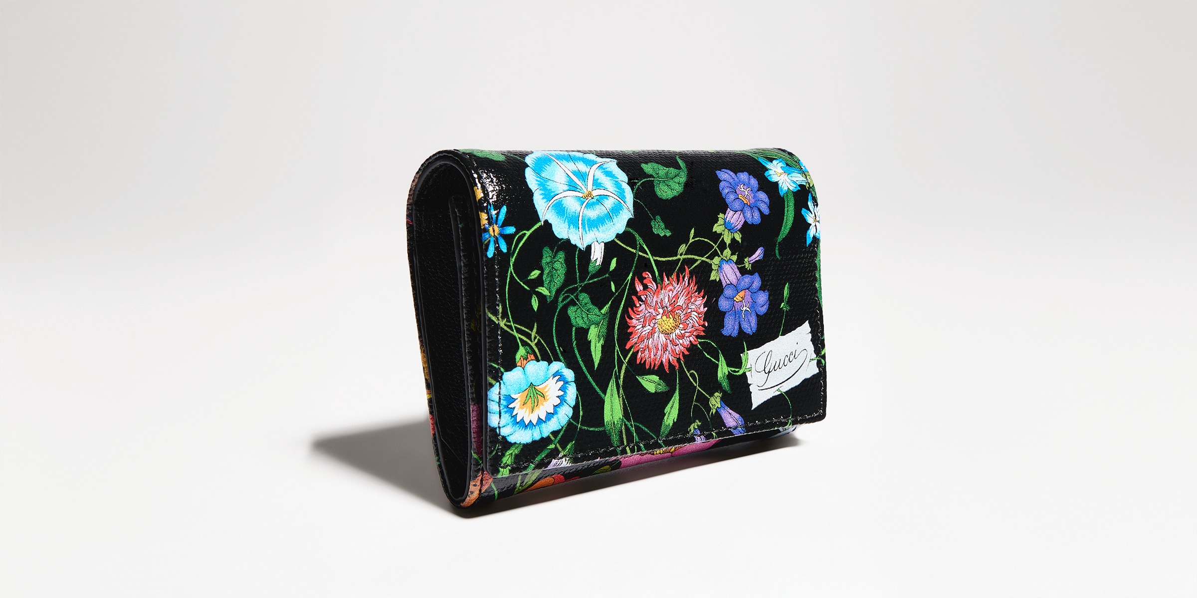 Flora-motif bi-fold card case in black and multicolor canvas