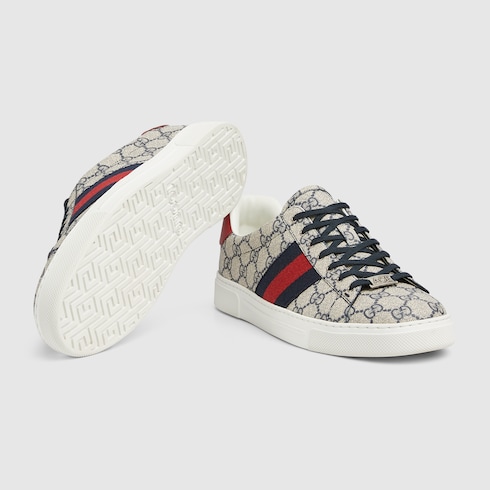 Gucci Ace Herrensneaker mit Web in beigefarbener und blauer GG Supreme GUCCI DE