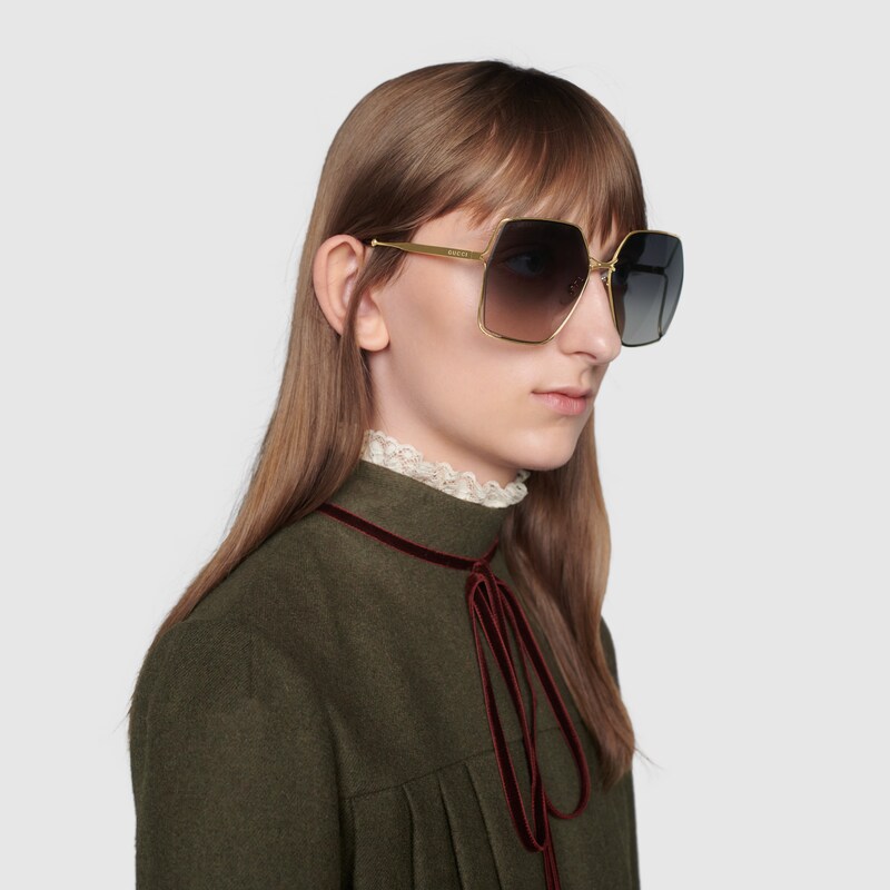 Occhiali da sole ovali in metallo color oro e grigio | GUCCI® Italia